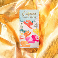 A box of California Gummy Bears on a yellow background with a festive design featuring gummy bears on snowboards.